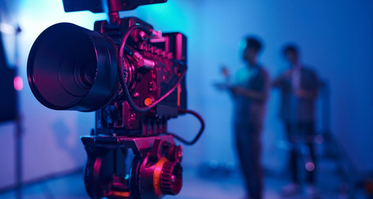 Close-up of professional camera for professional shooting with camera crew in background
